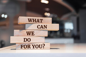 Wooden blocks with words 'What Can We Do For You?'.