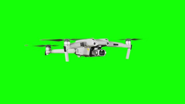 Drone hovering in the air on a green screen. Real quadcopter with camera flights on transparent background. Isolated portable copter on alpha matte. Aircraft blades rotate in hanging. Alpha channel 4K