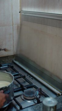 woman placing the pot on the stove and stirring it, closeup