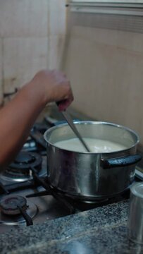 woman placing the pot on the stove and stirring it, closeup