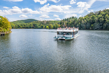 Boat with tourists on Lake Rursee, In the middle of the Eifel National Park, surrounded by unique...