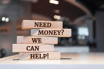 Wooden blocks with words 'Need Money? We Can Help!'.