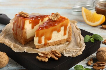 Pieces of delicious caramel cheesecake with walnuts served on table, closeup