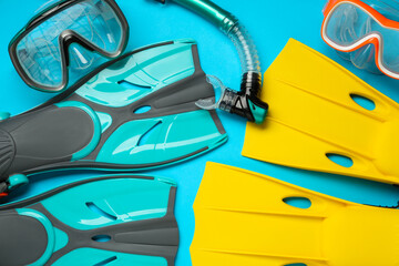 Different flippers and mask on light blue background, flat lay © New Africa