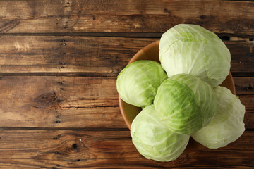 Ripe white cabbage on wooden table, top view. Space for text