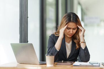 Stress asian business woman after working hard at office workplace.
