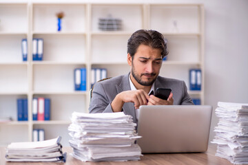 Young male employee and too much work in the office