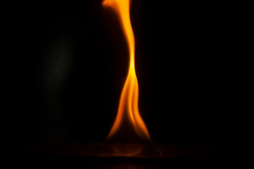 Flames in dark. One flame on black background. Ignition details. Fire burns yellow.