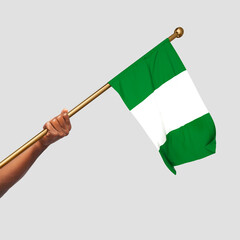 Hand holding Nigerian national flag isolated on gray background