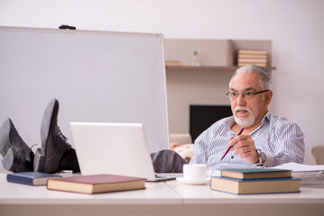 Old male employee working from home during pandemic