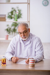 Old male dentist working in the clinic