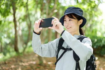 スマートフォンで写真を撮る山ガール