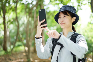 スマートフォンで写真を撮る山ガール