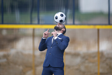 Businessman playing soccer ball.