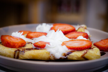 Close up de crepas con fresa y crema