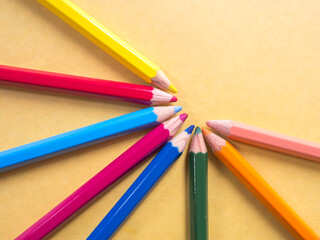 Naklejka premium Color pencils on yellow paper background; art for preschool concept; children hobby concept