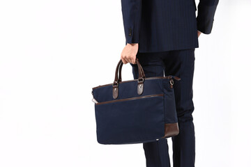 ビジネスバッグを持ったスーツ姿の匿名の人物