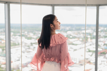 Business woman looking out the window in the office