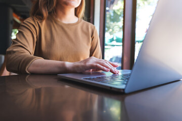 Closeup image of a woman working and touching on laptop computer touchpad