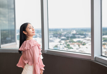 Fototapeta premium Business woman looking out the window in the office