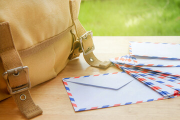 Mail envelopes and canvas shoulder bag on wooden table - obrazy, fototapety, plakaty