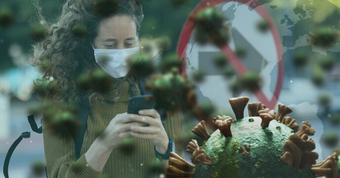 Covid-19 cells against woman wearing face mask using smartphone