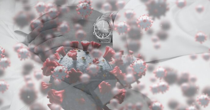 Man hand annd his watch over coronavirus covid19 cells floating