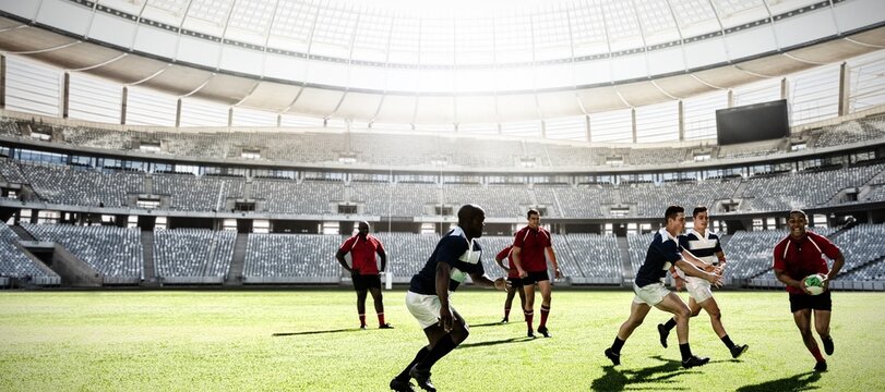 Digital composite image of team of rugby players playing rugby in sports stadium