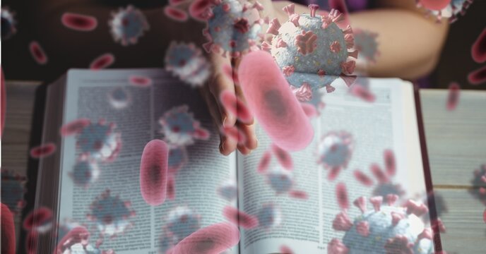 Covid-19 cells against hands praying over bible