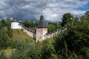Fototapeta na wymiar View of the wall of the Holy Dormition Pskov-Pechersk Monastery, the Tower of the Upper Lattices, Tailovskaya tower on a sunny summer day, Pechory, Pskov region, Russia
