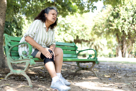 Senior woman suffering with knee pain during morning walk