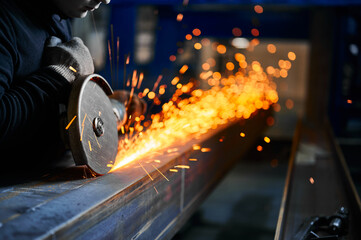 Cutting of metal beam with abrasive tool at metalwork plant