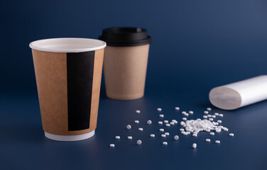 Paper cups and scattered sweetener tablets on a blue background. Sugar substitute is a concept of proper nutrition. Zero waste. Horizontal orientation, copy space, no people