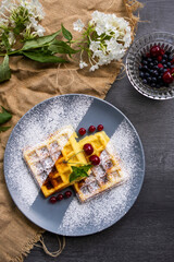 Holiday table with food. A plate with waffles and berries.