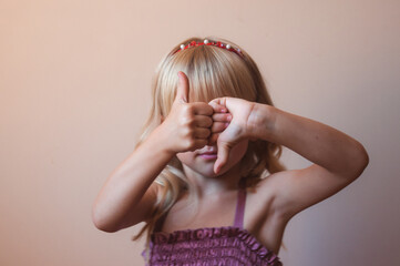 Close-up portrait of a white-haired girl. The child shows like and dislike.