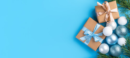 Christmas background with gifts, ribbons, toys and pine branches on a light blue background. The...