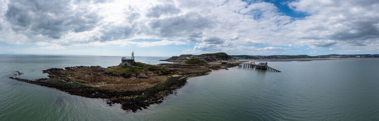 view of the Mumbles headland with the historic lighthouse and piers in Swansea Bay