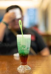 Es cendol is Indonesia traditional iced dessert. Popular during fasting in Ramadan. A refreshing cold drink when drunk in the afternoon. Tired man as a bokeh background.