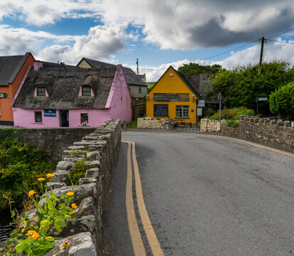 bridge leads to colorful houses in the old village center of Doolin