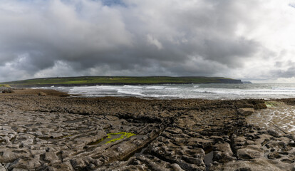 panorama view of the glaciokarst coastline at Doolin Harbor with the Cliffs of Moher in the background