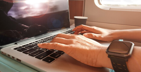 Nomad digital woman hand  as she is a freelance working  a vacation with laptop in the train at the...