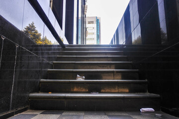 dirty black marble staircase full of trash and dust outside a building