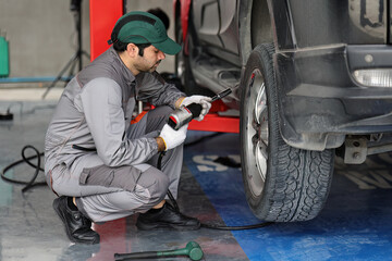Mechanic changing a wheel of a modern car