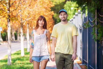 Obraz premium Portrait of young couple walking down the street. Happy caucasian woman with tattoos and bearded smiling man spend time together. The concept of relationship psychology