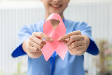 Asian Doctor holding pink ribbon smile positive emotional for supporting people to heal and fight...