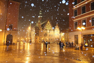 Polska policja na służbie zimą w czasie opadów śniegu wieczorem. 