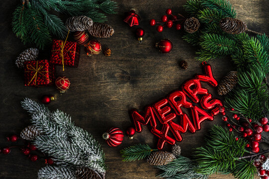 Overhead View Of Merry Xmas Decoration With Fir Branches, Christmas Baubles, Pinecones And Ornaments