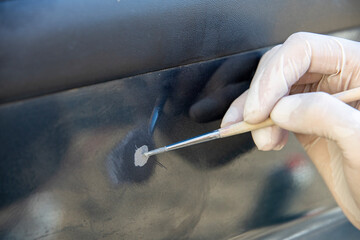 The car painter pointwise brings the primer with a brush into the paint layer.