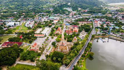 Drone aerial view , traveler with backpack traveling into beautiful pagoda in Wat Chalong or Chalong temple at Phuket town, Thailand. It's most popular thai temple in Phuket Thailand.