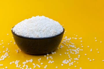 Organic Sago or Sabudana in a Black Bowl Isolated on Yellow Background with Copy Space